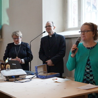 Hannu ja Elina Heikkilä puhumassa kirkkoyleisölle mikrofoneihin.