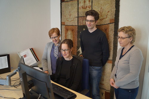 Neljä viraston työntekijää katsoo yhdessä tietokoneen näyttöpäätettä.
