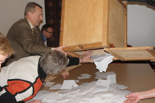 Vaalien äänenlaskijat tyhjentävät äänestyslappuja sisältävää laatikkoa.