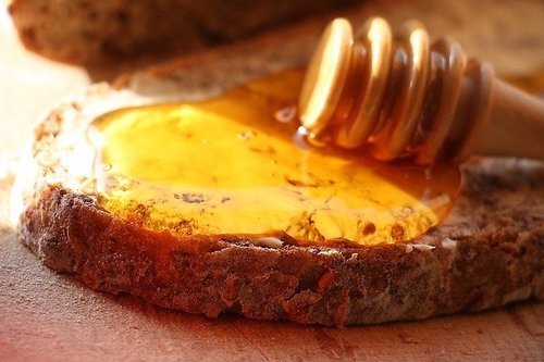 Leipäviipaleen päälle levitettyä hunajaa.