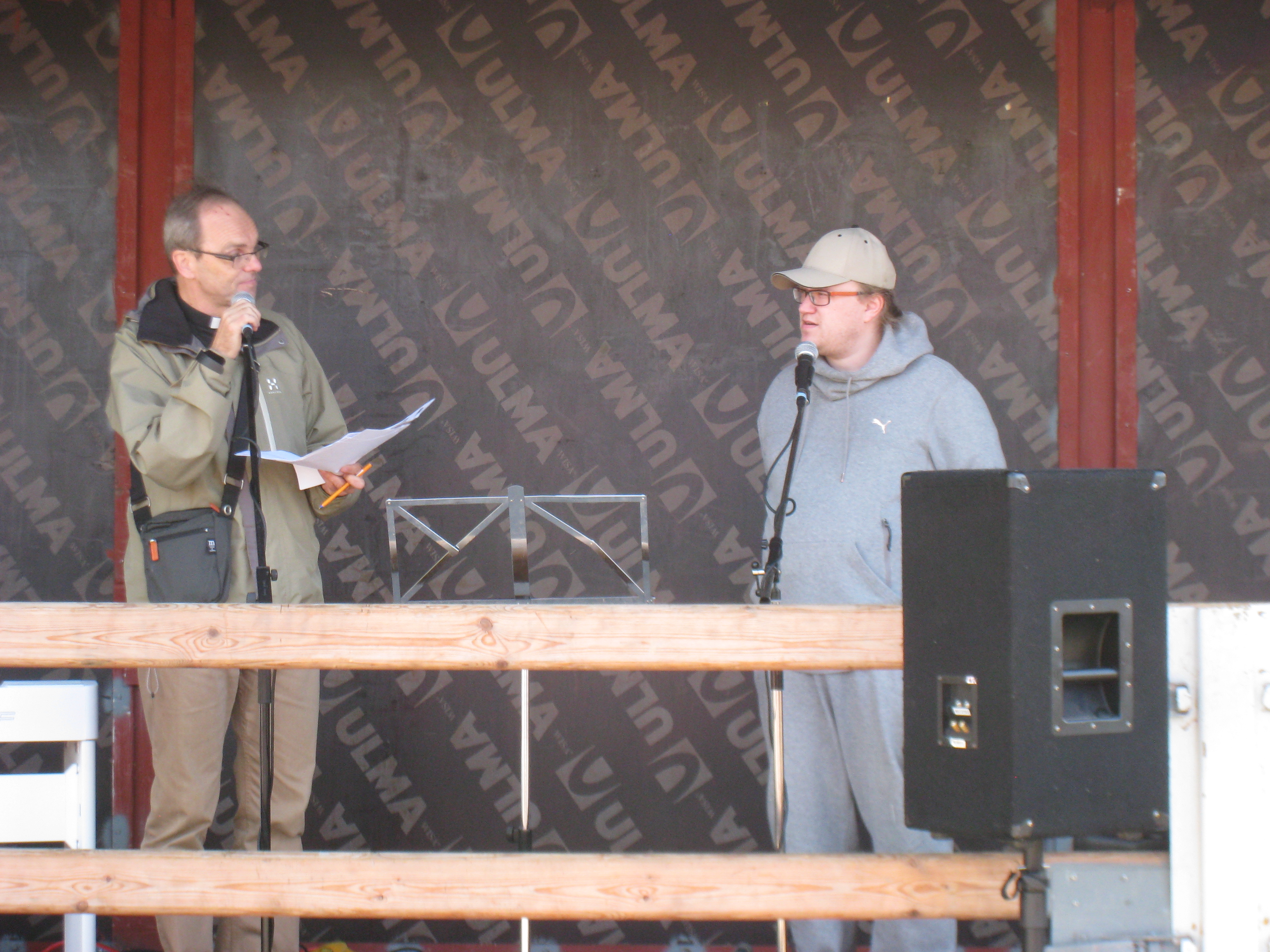 Lähetystyöntekijät puhuvat mikrofoneihin lähetystorin lavalla.